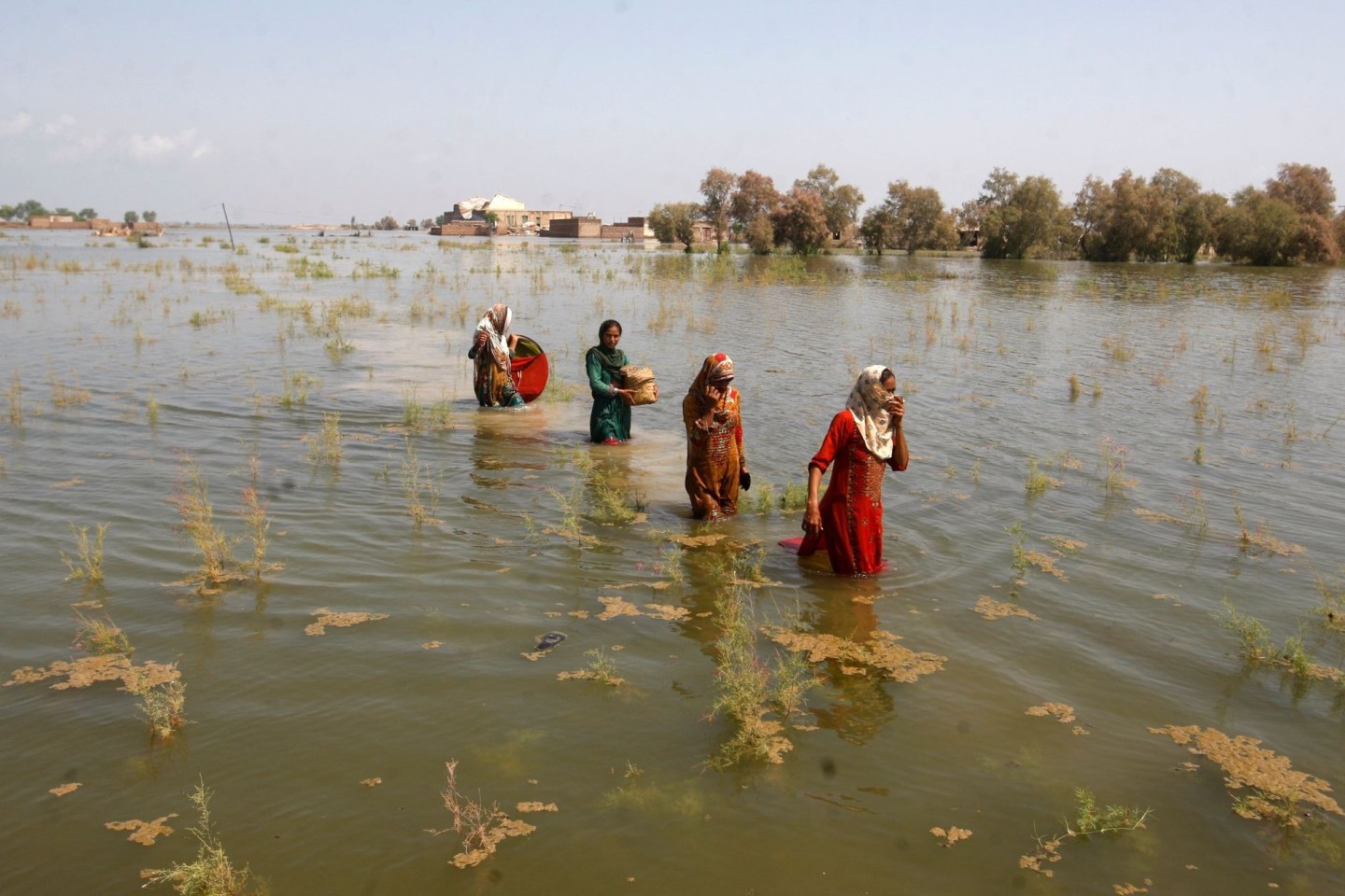 Pakistanische Frauen waten durch die Fluten auf der Suche nach Zuflucht.