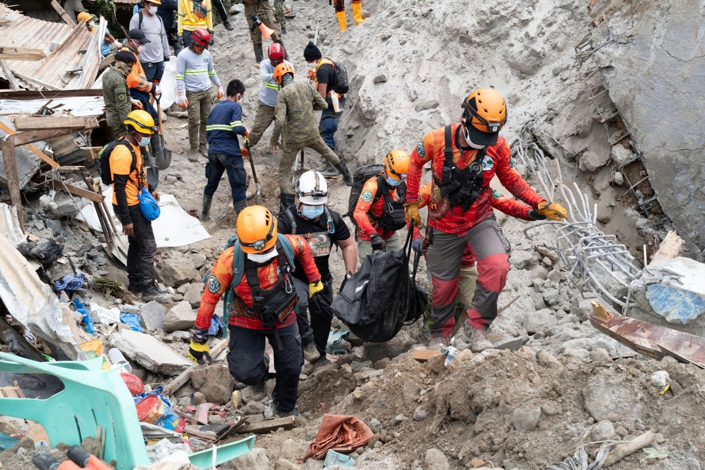 Rettungskräfte tragen ein Opfer aus dem von einem Erdrutsch betroffenen Dorf Masara.