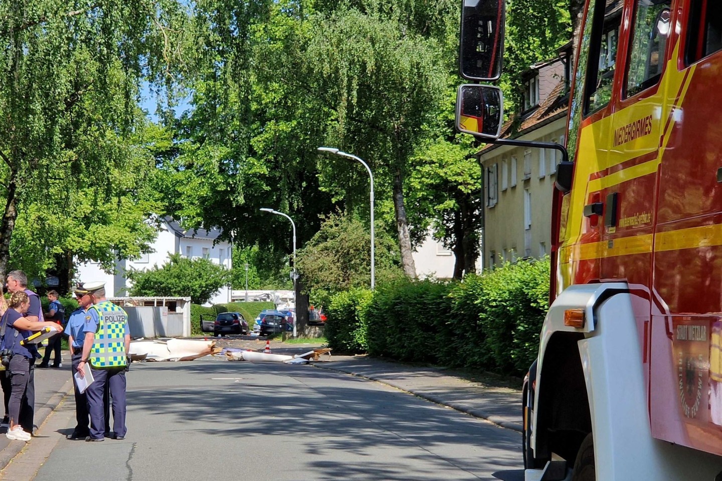 Trümmer liegen auf der Straße nach dem Absturz eines Segelflugzeugs im Stadtgebiet von Wetzlar.