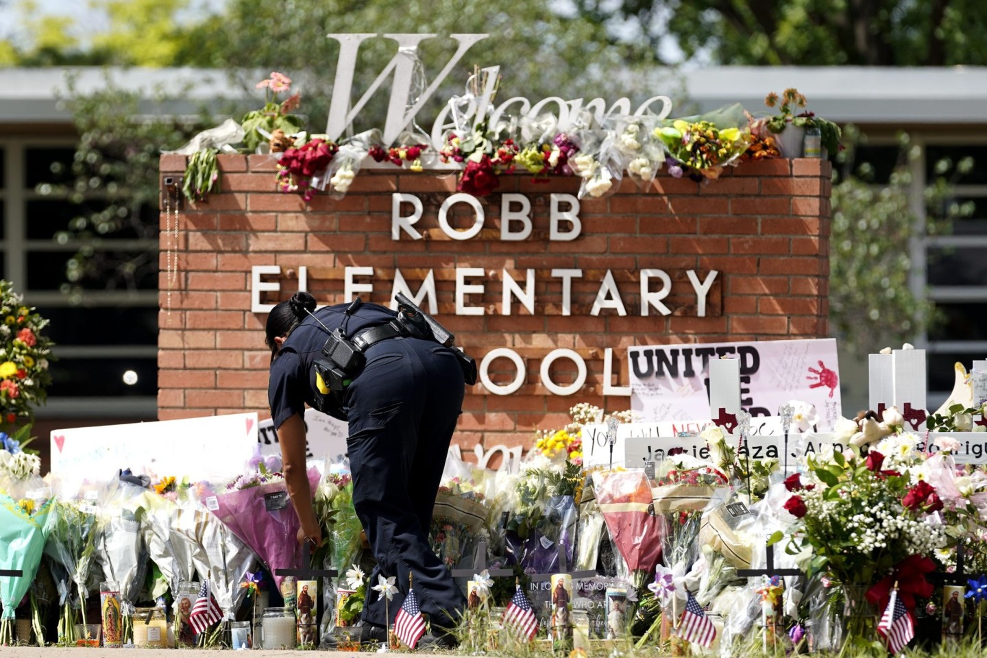 Eine Polizistin legt Blumen vor der Robb Elementary School in Texas nieder. Bei einem Schulmassaker hatte ein Schütze Ende Mai 19 Kinder und zwei Lehrerinnen erschossen.