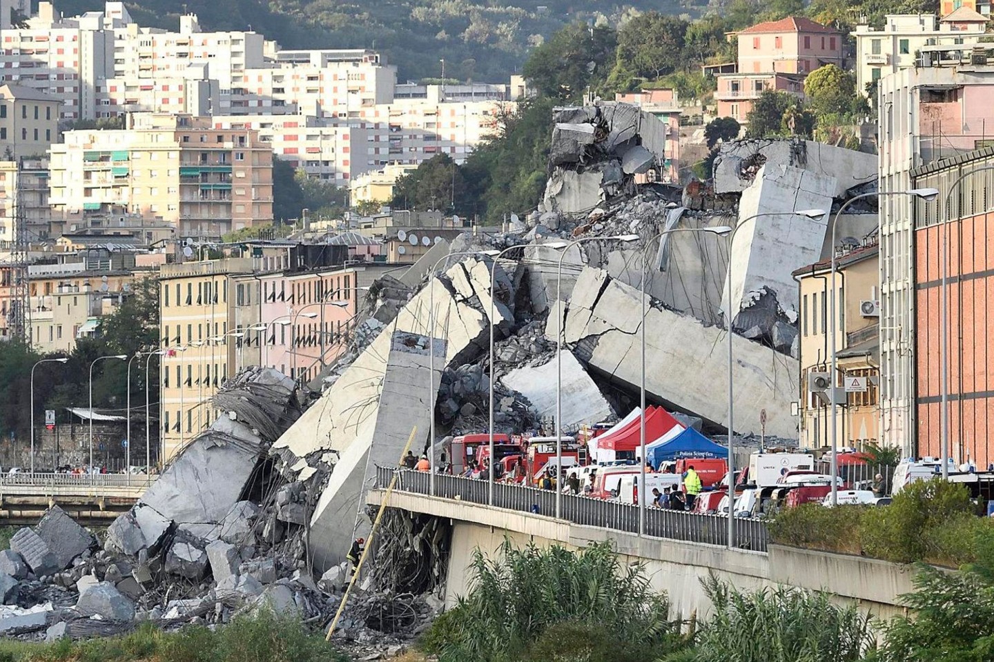 Fahrzeuge der Rettungskräfte stehen vor der teilweise eingestürzten Autobahnbrücke (2018).