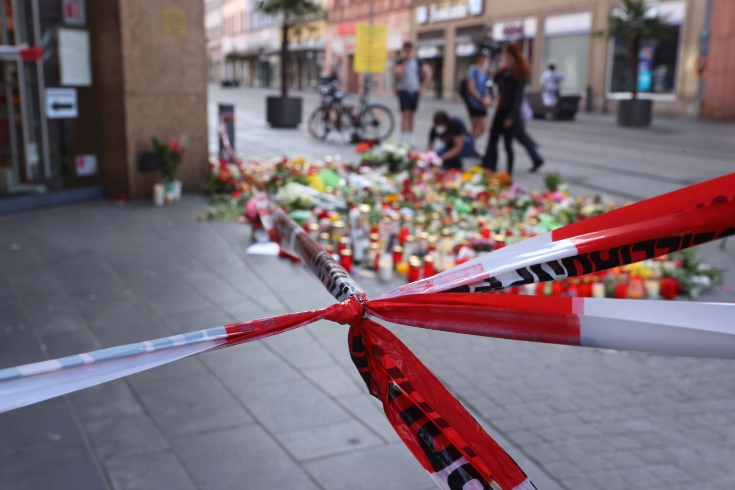 Blumen und Kerzen vor dem abgesperrten Kaufhaus, wo ein Mann Menschen mit einem Messer attackiert hatte.