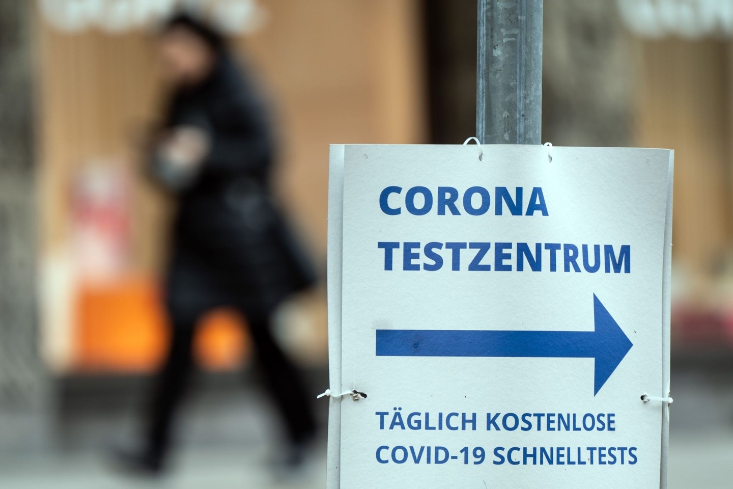 Ein Pappschild weist die Richtung zu einem Corona-Testzentrum in Düsseldorf.