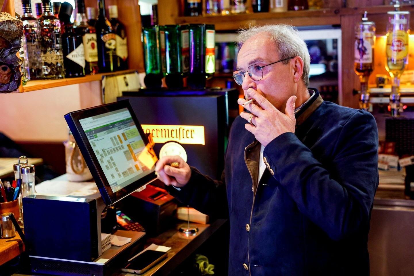 Peter Krall, Inhaber des «Hofbräu Raucher Stüberl» in Hamburg, raucht am Tresen seines Lokals eine Zigarette.