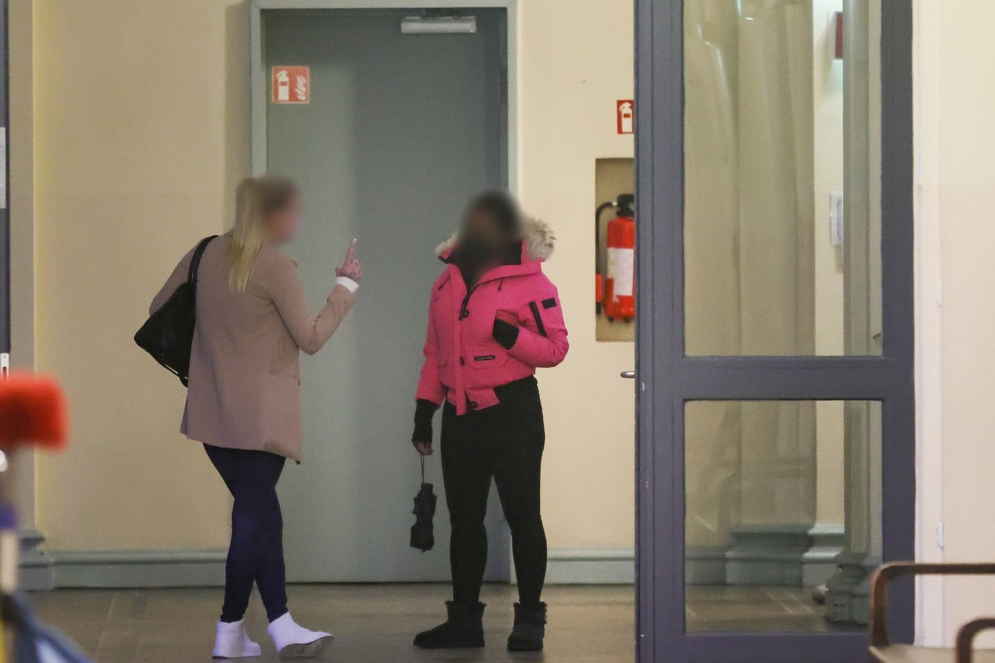 Zwei angeklagte Frauen warten vor einem Gerichtssaal im Strafjustitzgebäude in Hamburg auf den Beginn der Verhandlung.