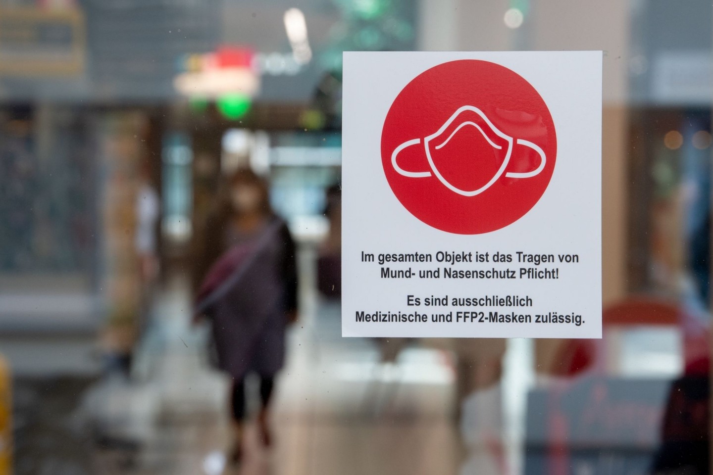 Ein Schild am Eingang zu einer Einkaufspassage weist auf das Tragen von Mund- und Nasenschutz hin.