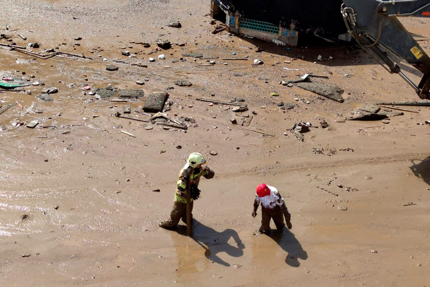 Dieses vom iranischen Roten Halbmond zur Verfügung gestellte Bild zeigt Rettungskräfte bei der Arbeit in Schlamm und Geröll am Ort einer Sturzflut.