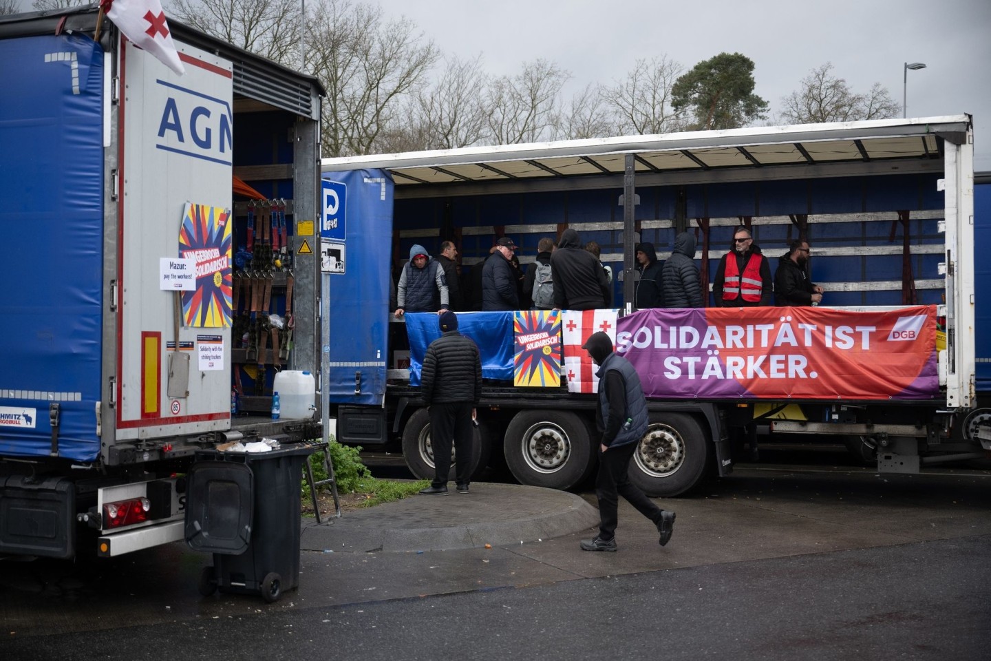 «Solidarität ist stärker» steht auf einem Banner. Die Lastwagenfahrer streiken auf einer Raststätte. Sie fordern ausstehenden Lohn von ihrem Arbeitgeber.