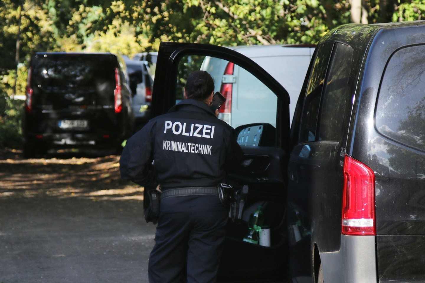 Eine Kriminaltechnikerin in Berlin neben Fahrzeugen der Polizei. Die Bahn wurde Opfer eines gezielten Angriffs.