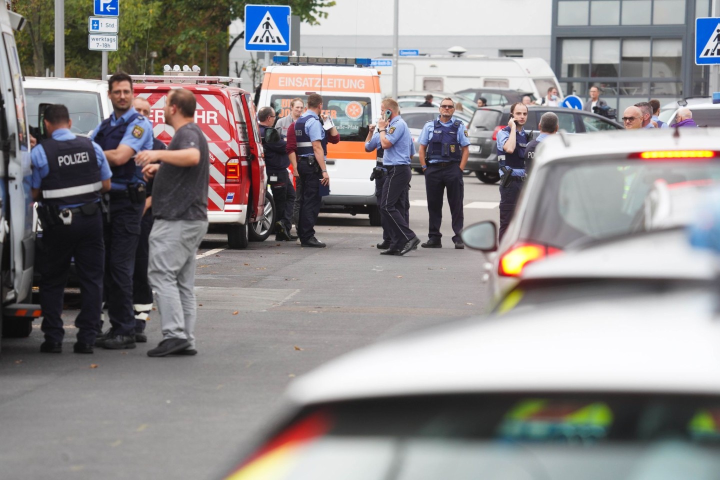 Polizisten und Rettungskräfte stehen an einem der Tatorte in Ludwigshafen.