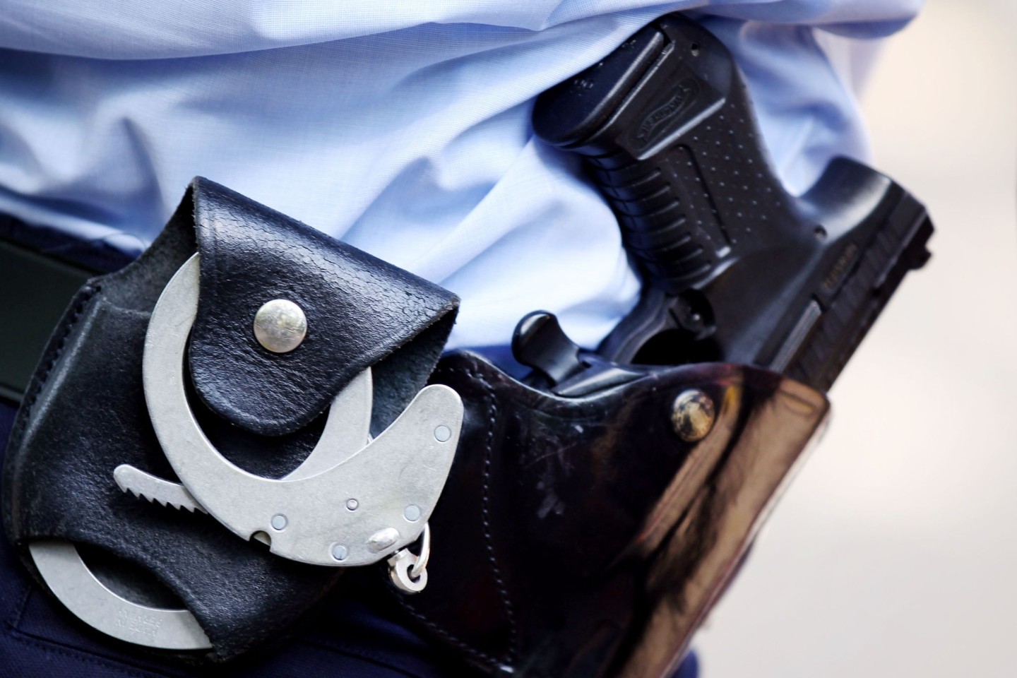 Ein Polizist mit Handschellen und Pistole am Gürtel (Symbolfoto).