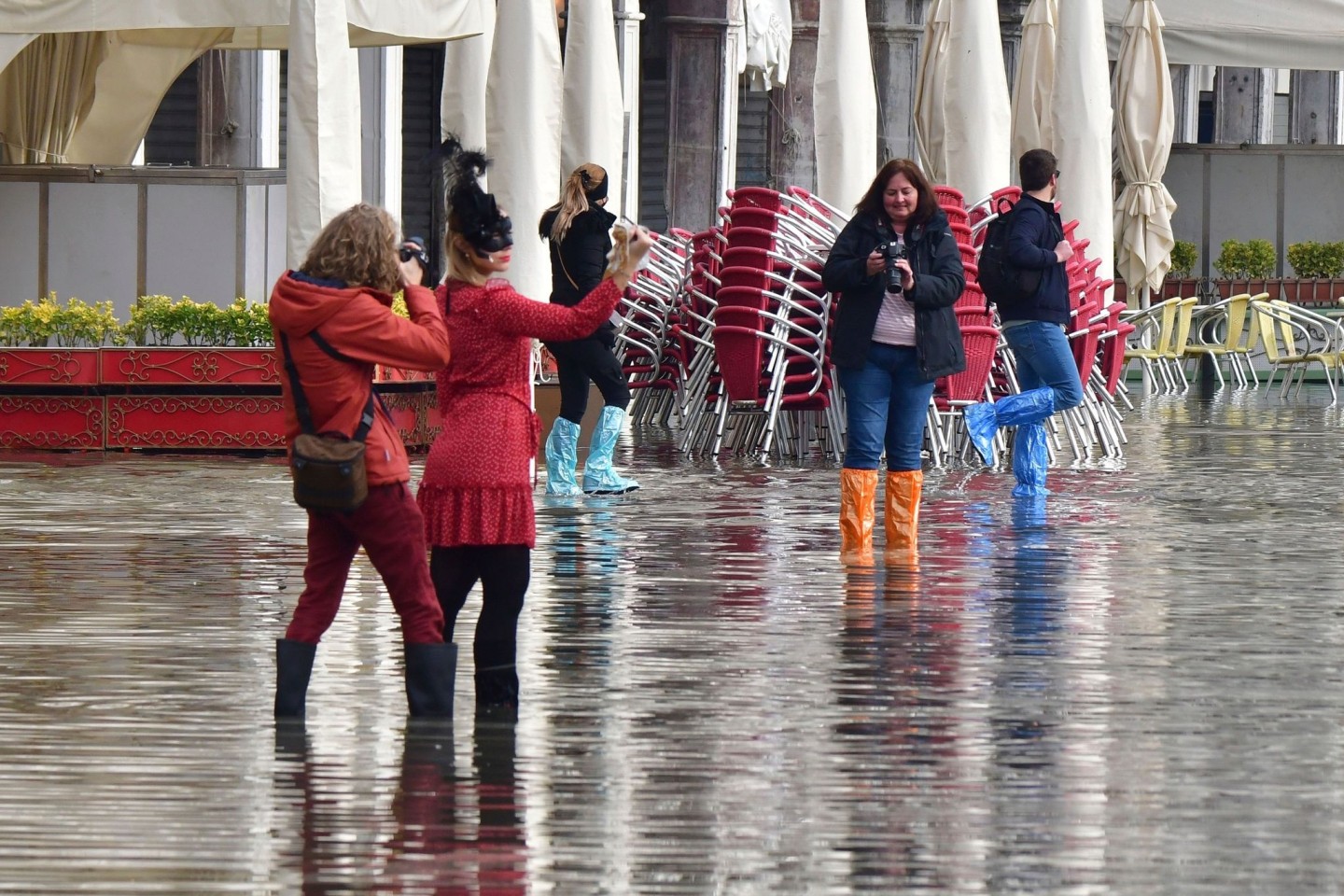 Menschen auf dem überfluteten Markusplatz in Venedig.