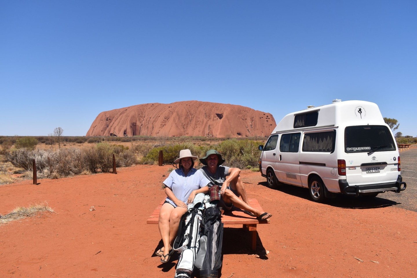 Menekse (l) und James Humphrey neben ihrem Van und vor dem Uluru (Ayers Rock) im Outback Australiens.