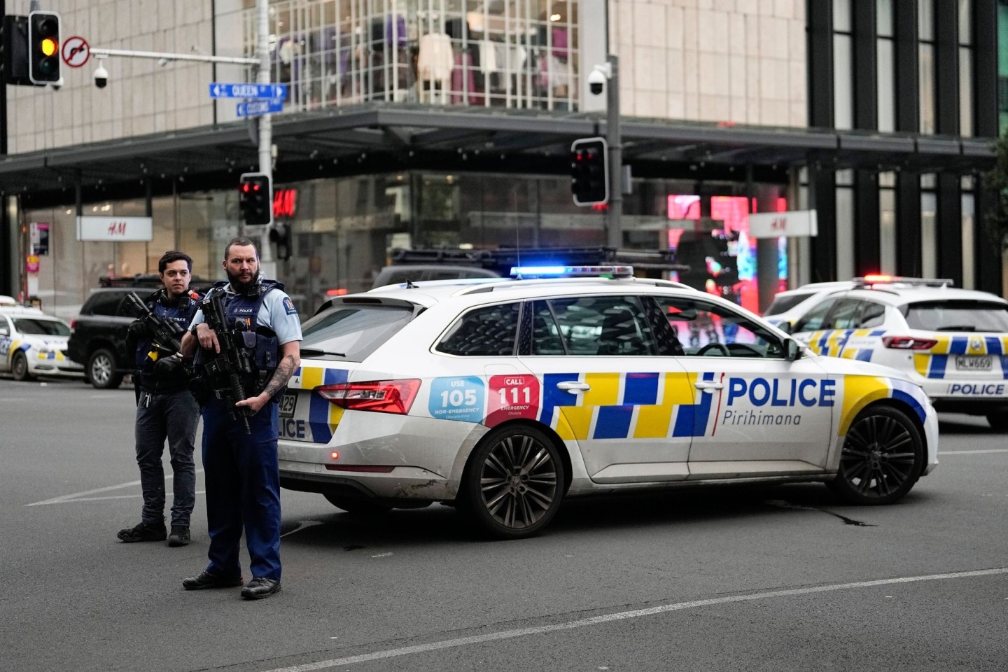 Bewaffnete neuseeländische Polizisten stehen an einer Straßensperre, nachdem in Auckland Schüsse gefallen waren.