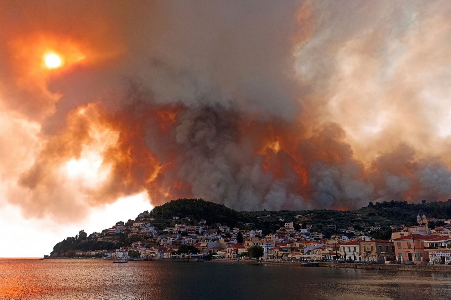 Rauch eines Waldbrandes steigt hinter einem Berghang in dem Ort Limni auf der Halbinsel Euböa etwa 160 Kilometer nördlich von Athen auf.